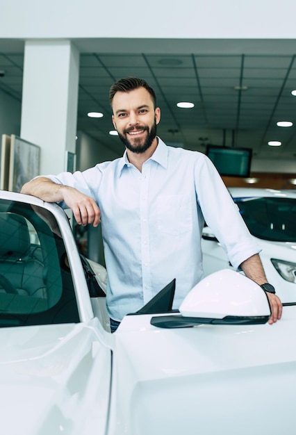 Exitoso apuesto hombre barbudo comprando un nuevo auto deportivo en el concesionario