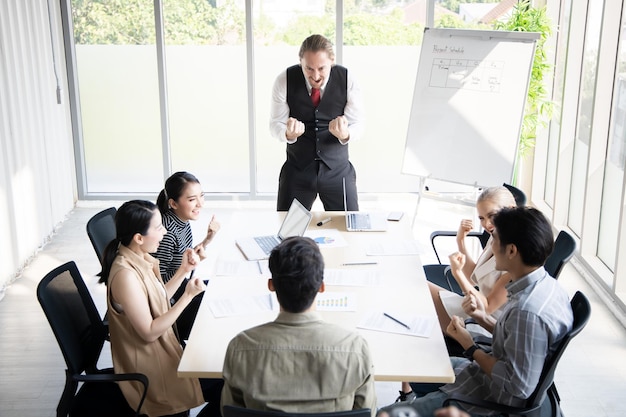 Exitoso equipo de empresarios haciendo gestos felices en la sala de conferencias. Concepto de éxito del trabajo en equipo.