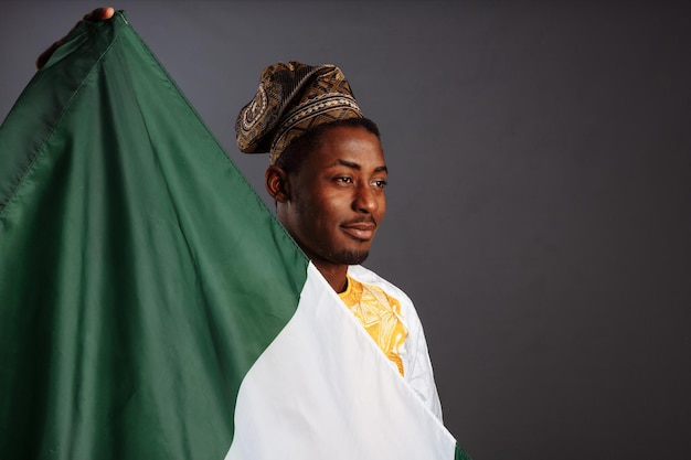 Exitoso ganador africano antes de ondear la bandera de Nigeria Sonriendo y mirando a la cámara