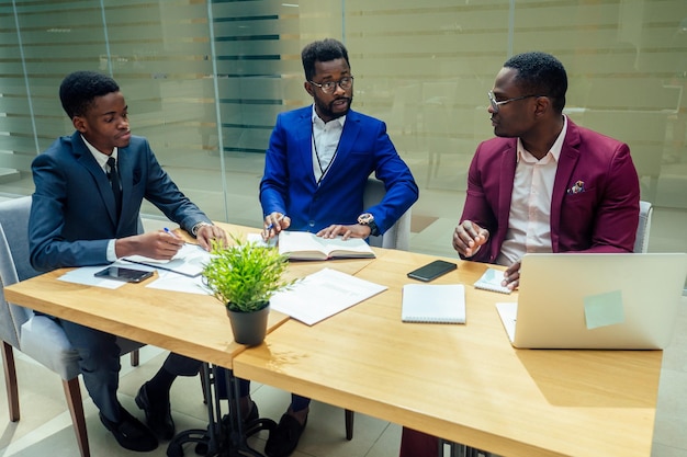 Exitoso grupo de confianza de empresas afroamericanas en oficinas modernas con grandes ventanales