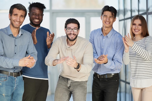 Exitoso grupo empresarial aplaudiendo en la oficina