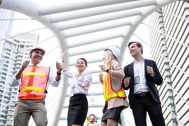 Exitoso grupo de empresarios e ingenieros con alegre al aire libre en la ciudad.