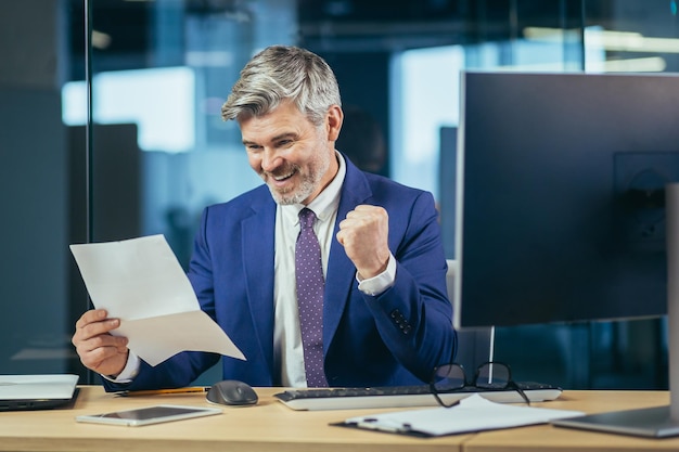 Exitoso hombre de negocios experimentado recibió una carta positiva un mensaje feliz del banco el jefe trabaja en una oficina moderna celebra la victoria