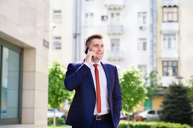 Exitoso hombre de negocios hablando por teléfono y sonriendo.