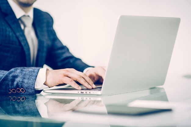 Foto un exitoso hombre de negocios que trabaja en la computadora portátil en el lugar de trabajo