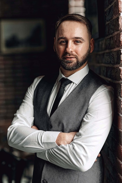 Exitoso joven empresario en un chaleco y corbata. con un elegante y elegante corte de pelo y barba