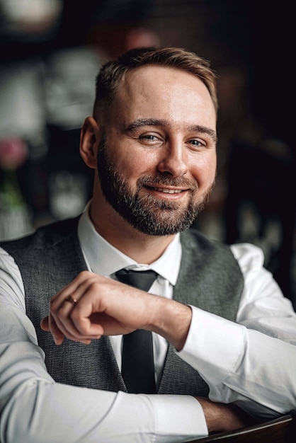 Exitoso joven empresario en un chaleco y corbata. con un elegante y elegante corte de pelo y barba