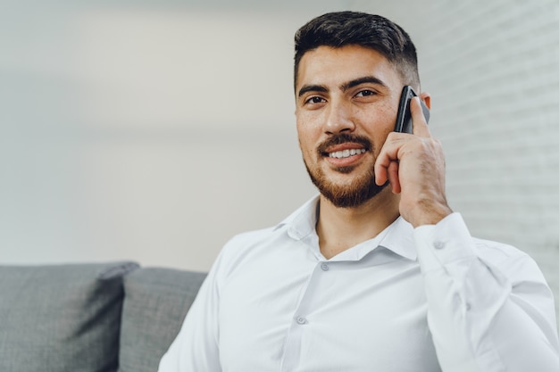 Exitoso joven empresario hablando por su teléfono celular, Retrato