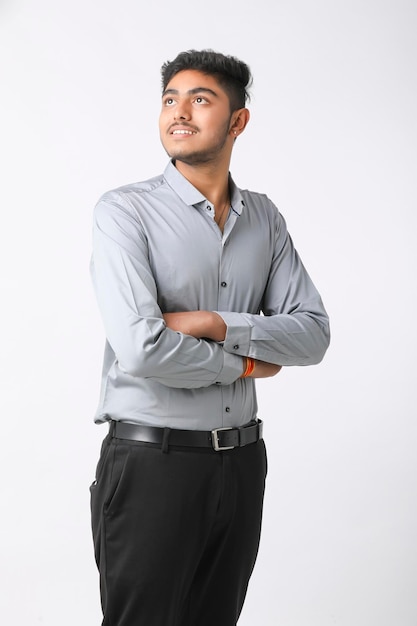 Exitoso joven hombre de negocios indio posando sobre fondo blanco