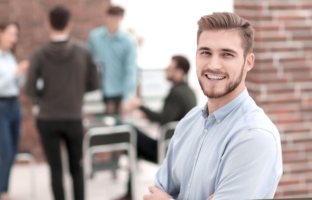 Exitoso joven hombre de negocios de pie con sus colegas en b