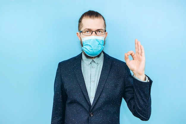 Un exitoso muschin en un traje, gafas y una máscara médica en azul