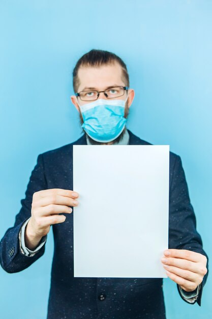 Un exitoso muschin en un traje, gafas y una máscara médica en azul