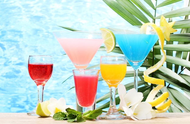 Exotische Cocktails und Blumen auf dem Tisch auf blauem Meeresgrund