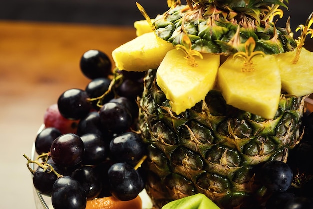 Exotische leckere Früchte auf einem Teller wie Ananas, Trauben, Orangen und Kiwi