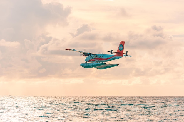 Exotische Szene mit Wasserflugzeug auf Malediven-Seelandung. Landung des Wasserflugzeugs auf Sonnenuntergangmeer. Urlaubsbanner