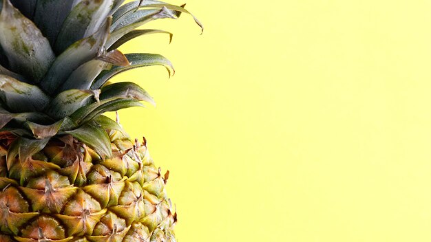 Exotische tropische Früchte auf gelbem Grund. Frische Ananas ist reich an Vitaminen.