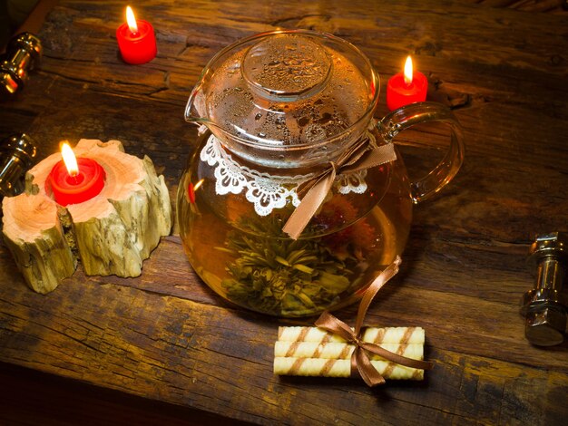 Exotischer grüner Tee mit Blumen in der Glasteekanne
