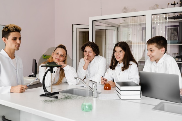 Experiência com fogo Professor de química da escola mostra experimentos de crianças no laboratório Conceito de educação Aula em grupo de colegas na aula de química