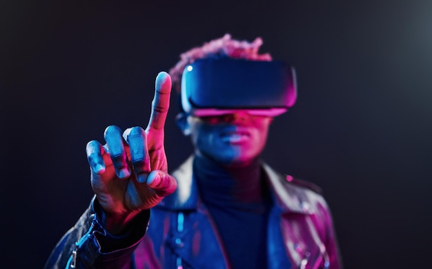 Experiência de realidade virtual Iluminação de neon futurista Jovem afro-americano no estúdio