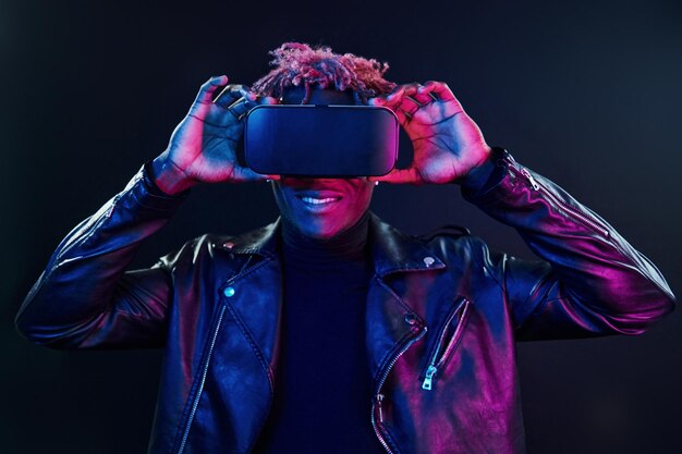 Experiencia de realidad virtual Iluminación de neón futurista Joven afroamericano en el estudio