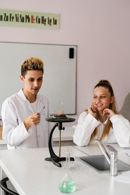 Experiment mit Feuer Schulchemielehrer zeigt Kindern Experimente im Labor Bildungskonzept Gruppenunterricht von Klassenkameraden im Chemieunterricht