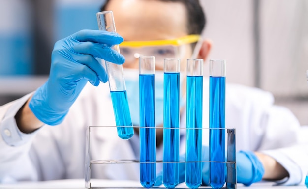 Experimento de líquido químico azul en equipos de cristalería científica en el descubrimiento de investigación de biología o química de laboratorio de medicina científica mediante el uso de vidrio de tubo de ensayo o vaso de precipitados y matraz