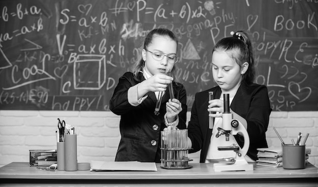 Experimentos científicos en laboratorio Lección escolar de biología Trabajo científico pequeño con microscopio Investigación química Niñas en el laboratorio escolar Educación escolar formal Nuevas ideas para la medicina