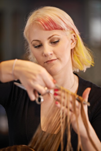 Experte bei der Arbeit Schnappschuss einer Friseurin, die einer Kundin die Haare schneidet