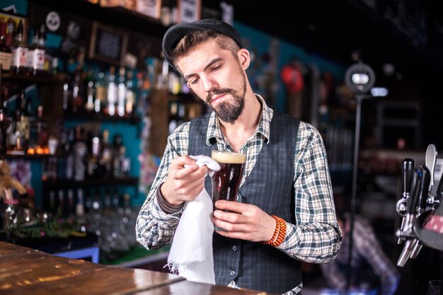 Experto mixólogo da los toques finales a una bebida tras la barra