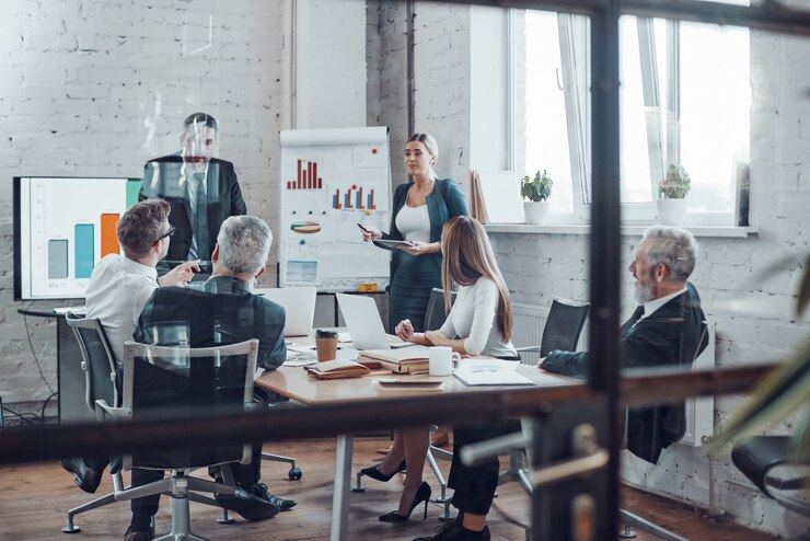 Foto experto en negocios profesional que presenta un informe analítico mientras trabaja junto con colegas en la oficina moderna