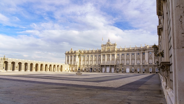 Explanada y gran patio del palacio real de Madrid al amanecer en un día con cielo azul y nubes. España.