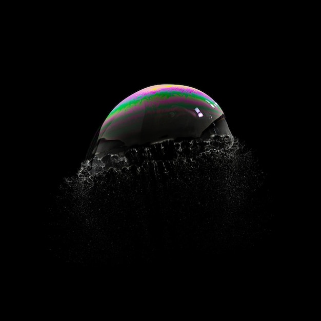 Explodierende Seifenblase in bunten Farben auf schwarzem Hintergrund