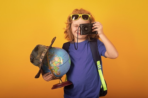 Foto explorador turístico infantil con mundo de globo retrato de estudio de un niño pequeño explorando la vida silvestre del mundo concepto de senderismo y aventura