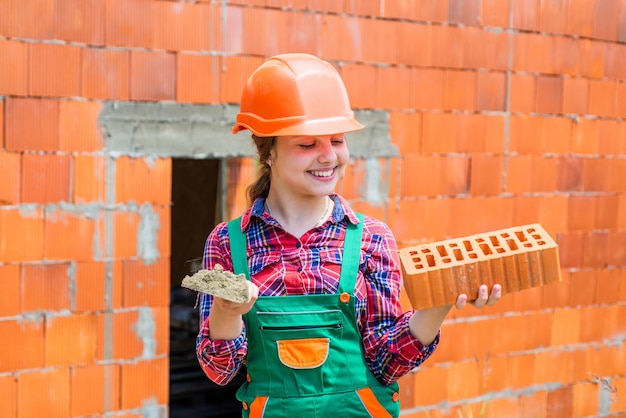 Explorando herramientas futuro ingeniero niño feliz usar ladrillo para renovación reparación edificio