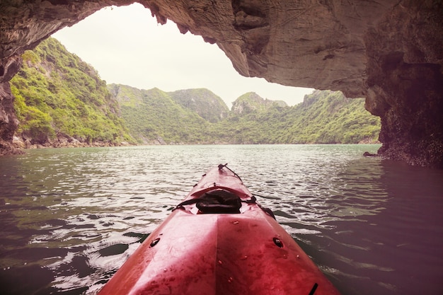 Explorar cavernas de canoa na baía de ha long, vietnã