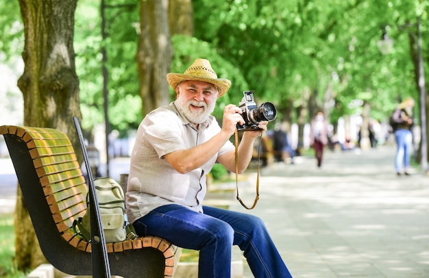 Explore a cidade. Passatempo turístico. Conceito turístico. Viagem e Turismo. Fotógrafo sentar-se no banco do parque. Capturando a beleza da primavera. Aproveitando o tempo livre. Andando em sua rua favorita. Último homem segurar a câmera.