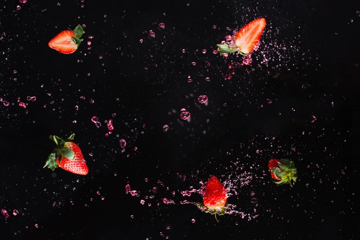 Explosão de Berry. Morango em respingos de água. Fundo preto