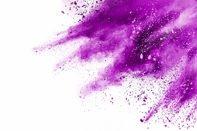 Foto explosão de partículas roxas em fundo branco. movimento congelado de respingos de poeira roxa no fundo.
