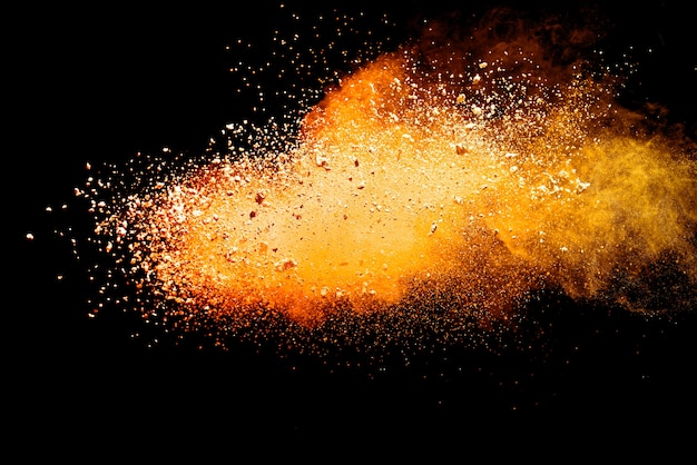 Foto explosão de pó laranja isolada em fundo preto