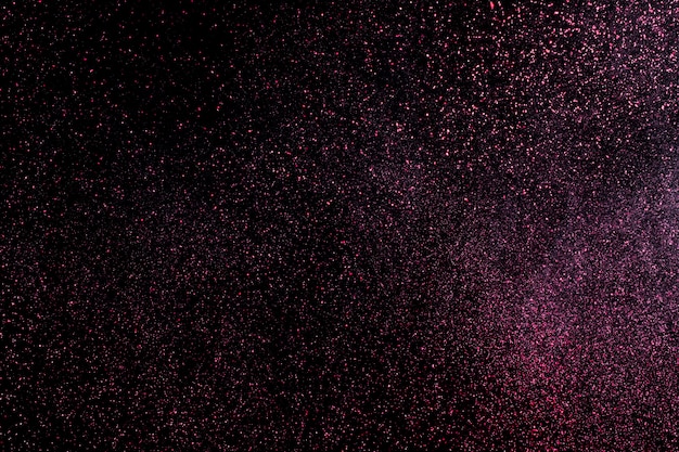 Foto explosão de poeira em um fundo preto para recursos gráficos.