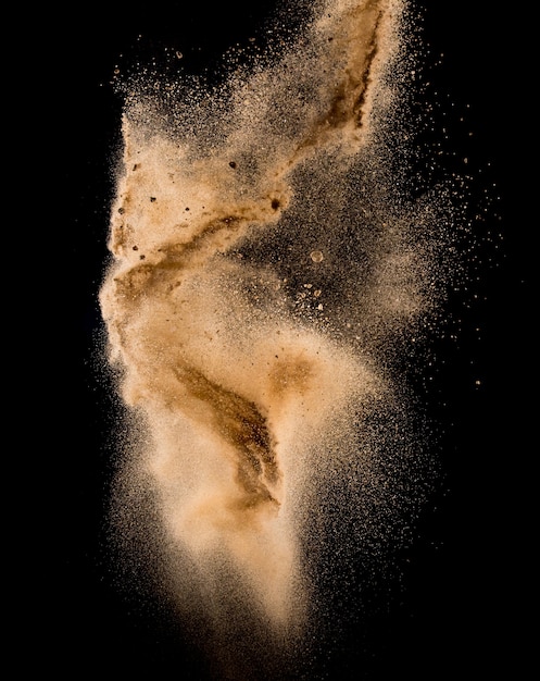 Foto explosión de arena aislado en más de fondo oscuro, nube de arena abstracta