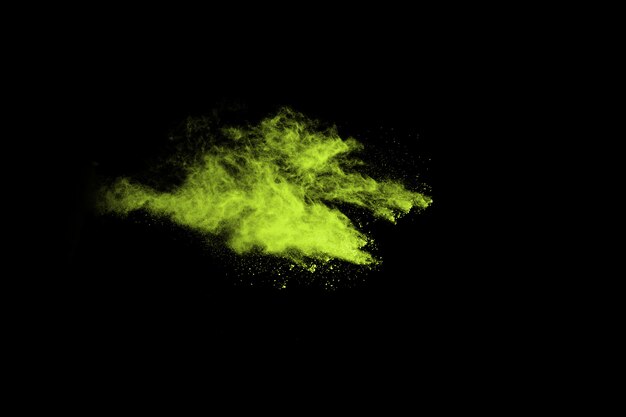 Foto explosión de polvo abstracto congelado verde sobre fondo negro.