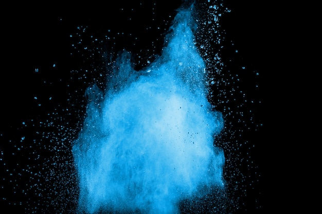 Explosión de polvo azul abstracta en fondo negro. Congelar el movimiento de polvo azul salpicaduras.