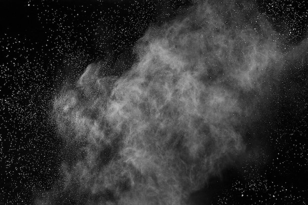 Explosión de polvo blanco sobre fondo negro. Nube de color El polvo colorido estalla.