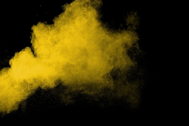 Explosión de polvo de color amarillo sobre fondo negro.