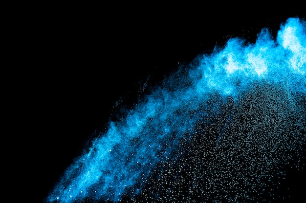 Explosión de polvo de color azul sobre fondo negro.