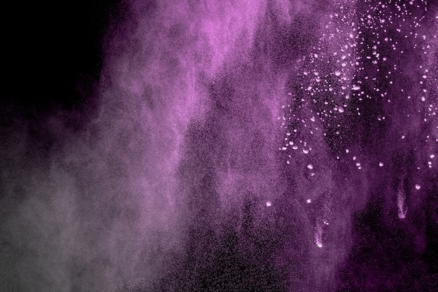 explosión de polvo de color púrpura sobre fondo negro.