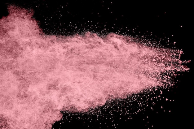 explosión de polvo de color rosa sobre fondo negro.