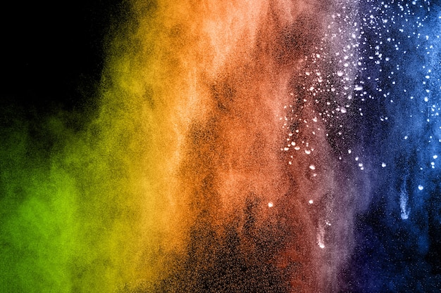 Explosión de polvo multicolor sobre fondo negro.