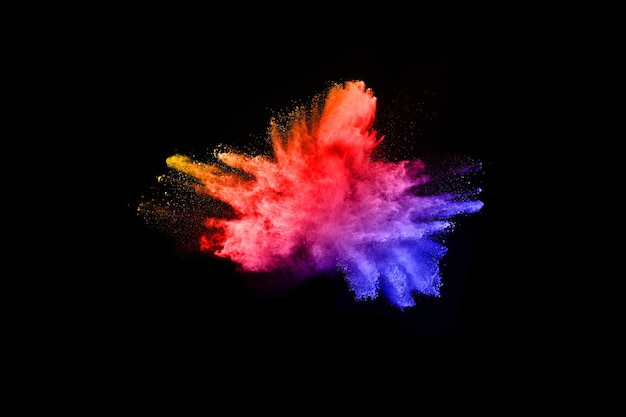 Explosión de polvo multicolor sobre fondo negro.